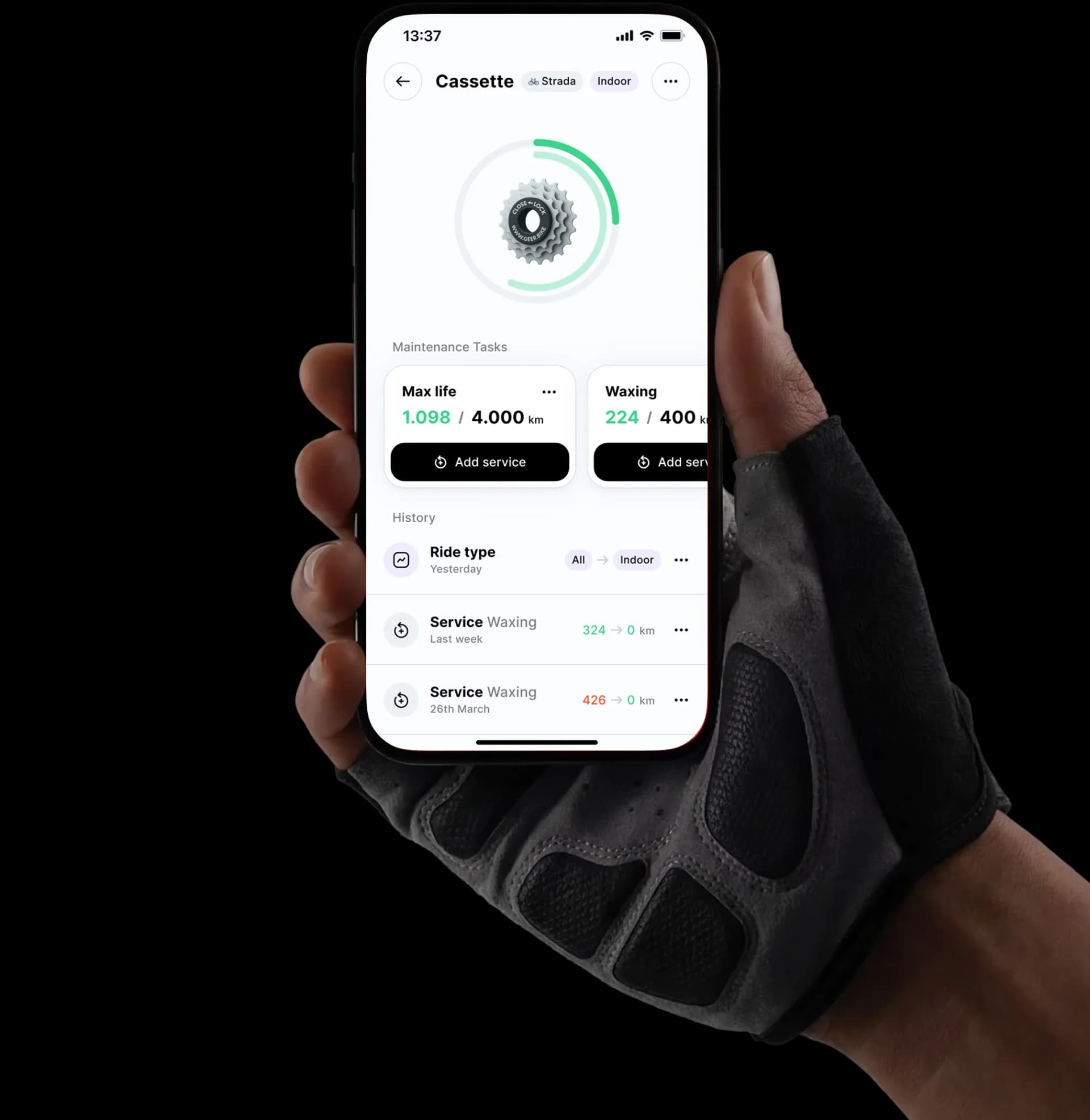 Hand holding a phone showing the Geer app with cassette maintenance tracking, service intervals, and ride history